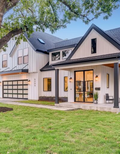 Modern two-story suburban home with a white exterior, black trim, and an attached garage.