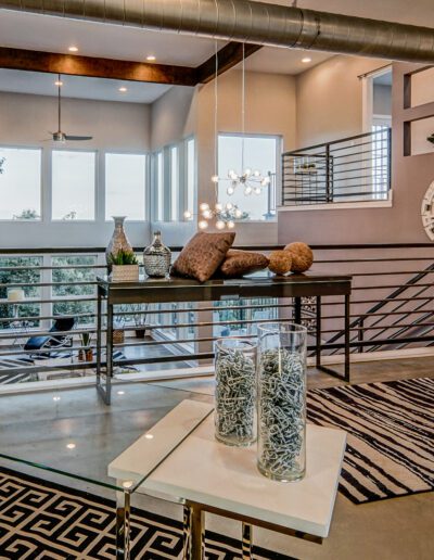 Modern living room with industrial design elements, high ceilings, and large windows.