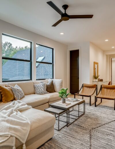 Modern living room with large windows, neutral color palette, and contemporary furniture.